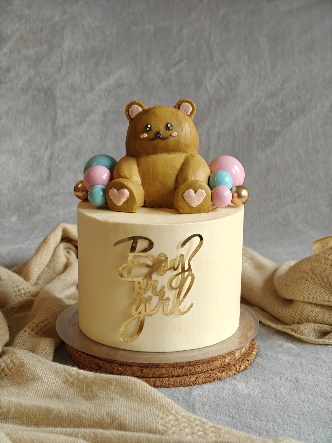 Gender-neutral baby shower cake with fondant teddy bear